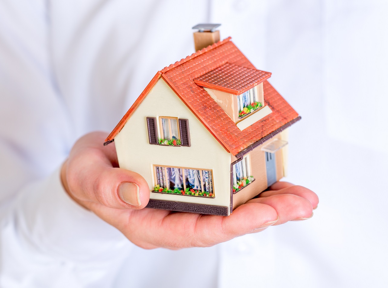 En hånd som holder et hus